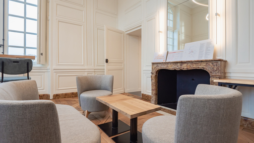 Espace détente avec une table basse en bois et un canapé au campus de Versailles.