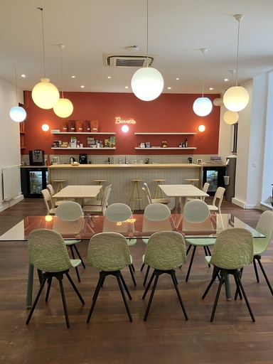 Espace détente avec une table basse en bois et un canapé au campus de Versailles.