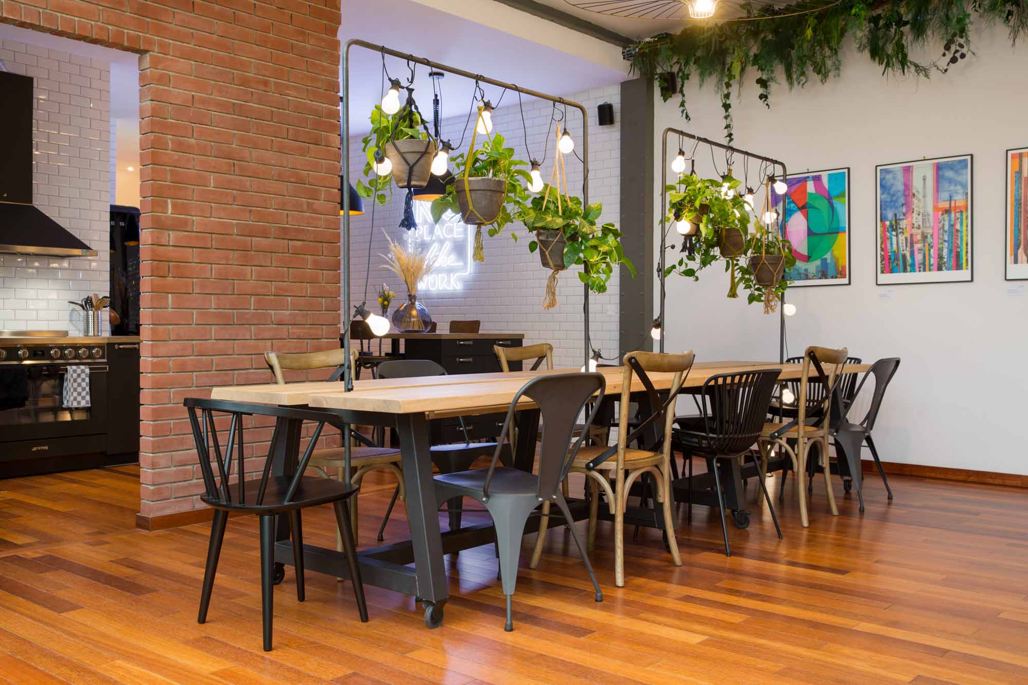 Un espace de travail végétalisé avec une Guinguette idéale pour du co-working, décorée avec des plantes suspendues à l'arche.