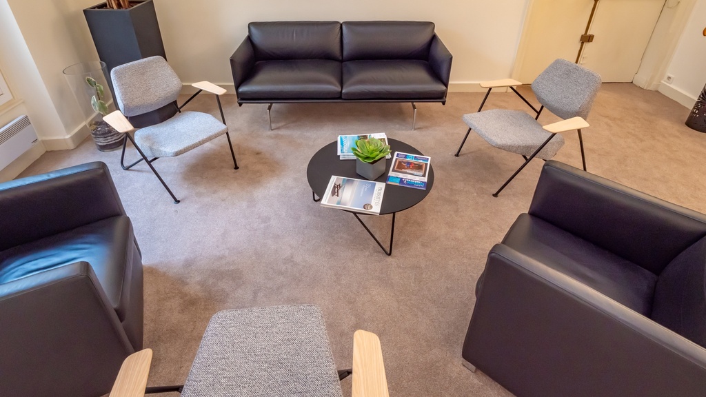 Espace accueil avec canapé, fauteuils et table basse